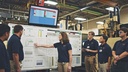 Team discussing project progress in a manufacturing setting