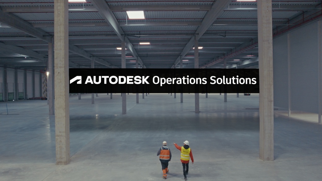 Two workers in a large, empty warehouse