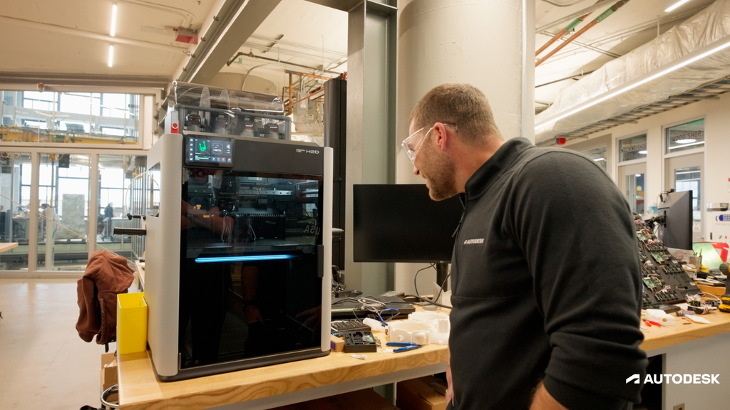 Engineer examining 3D printer in modern workspace